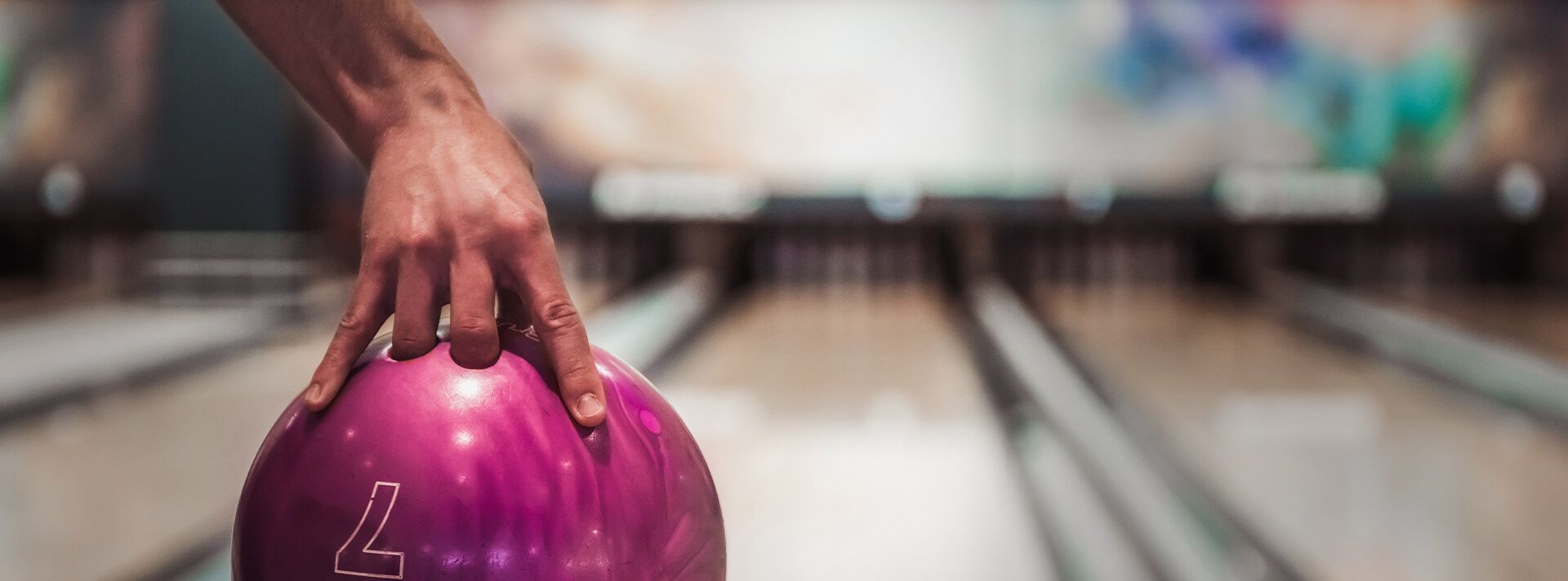 Eine Bowlingkugel vor einer Bowlingbahn in Szene gesetzt